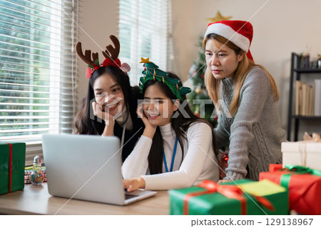 Festive Christmas Celebration with Friends Enjoying Holiday Spirit and Gift Exchange in Cozy Home Setting Festive Christmas Celebration with Friends Enjoying Holiday Spirit and Gift Exchange in Cozy Home Setting 129138967