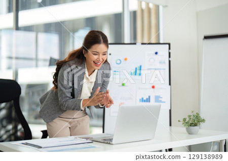 Professional Woman Celebrating Success in Modern Office 129138989