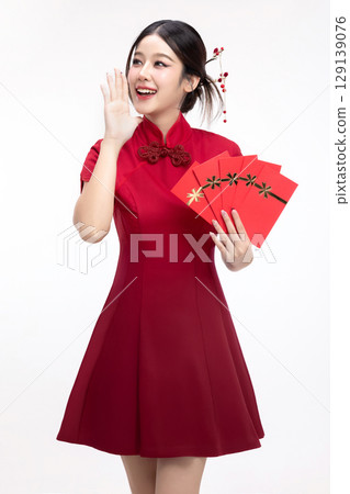 Portrait of joyful beauty Asian woman in red Cheongsam Chinese traditional dress celebrating with lucky red envelopes on Chinese New Year festival isolated on white background. 129139076