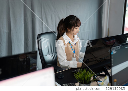 Young Professional Woman Working at Modern Office Desk with Computers and Technology 129139085