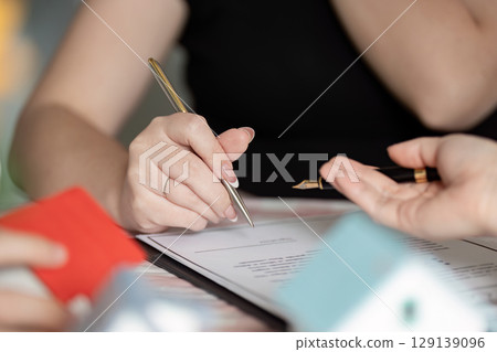 Professional Real Estate Agent Discussing Property Contract with client in a Modern Office Setting Professional Real Estate Agent Discussing Property Contract with client in a Modern Office Setting 129139096