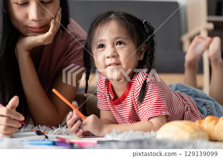 Young Child Engaged in Learning Activities at Home with Parent, Fostering Creativity and Education in a Comfortable Environment 129139099