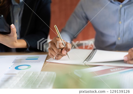 Business Collaboration. Professionals discussing financial reports and strategies in a modern office. 129139126