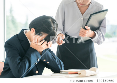 一名女老師嚴厲斥責一名因成績不佳（考試、應考、考試憂鬱、壓力）而蒙臉的女學生 129139660