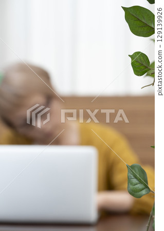 Elderly people looking at a computer in the living room, worrying about their senior women's lifestyle, dementia Elderly people looking at a computer in the living room, worrying about their senior women's lifestyle, dementia 129139926
