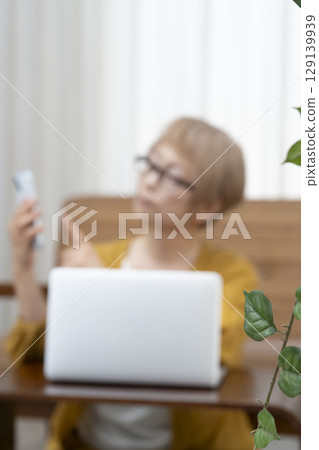 Elderly people looking at a computer in the living room, worrying about their senior women's lifestyle, dementia 129139939