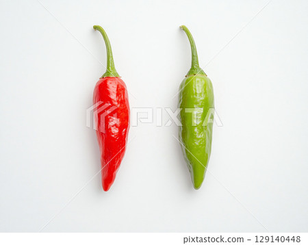 Fresh red and green chili peppers on white background, showcasing their vibrant colors and smooth textures. These peppers add spicy touch to various dishes and are popular in many cuisines 129140448