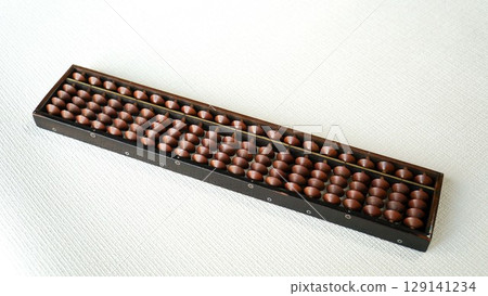 An old wooden Japanese abacus placed on a white background An old wooden Japanese abacus placed on a white background 129141234