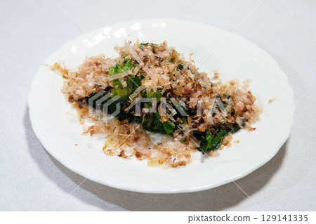 Boiled spinach and plenty of bonito flakes served on a white plate Boiled spinach and plenty of bonito flakes served on a white plate 129141335