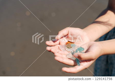 The palm of a child's hand after picking up sea glass 129141756