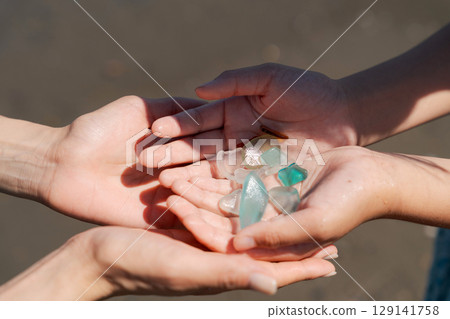 The palm of a child's hand after picking up sea glass 129141758