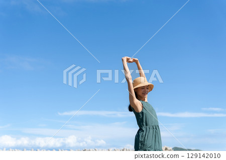 Young woman standing in the blue sea 129142010
