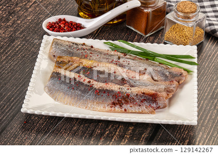 Salted marinated herring fillet with spices Salted marinated herring fillet with spices 129142267