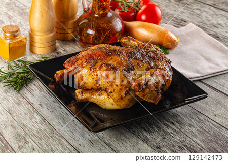 Baked in oven whole chicken with spices 129142473