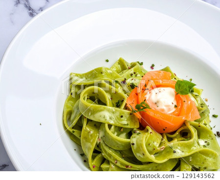 Matcha fettuccine on a white plate: salmon rose and cheese cream sauce 129143562