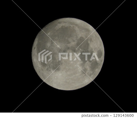Full moon floating in the night sky 129143600
