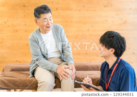 Asian male physiotherapist/massage therapist counseling senior man 129144031