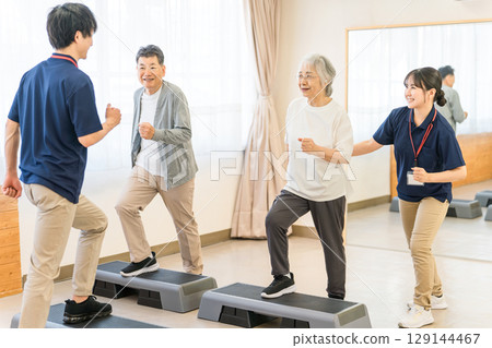 資深男女和年輕男教練在日間服務私人健身房進行訓練 129144467