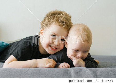 Happy Brothers Lying On Gray Sofa Happy Brothers Lying On Gray Sofa 129144635