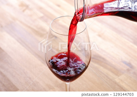 慢慢地將紅酒倒入酒杯中 慢慢地將紅酒倒入酒杯中 129144703