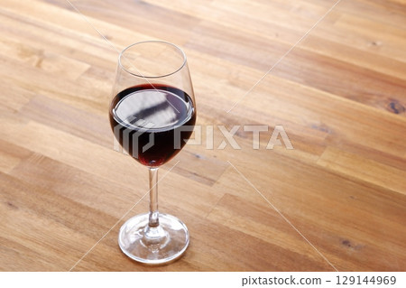 Red wine poured into a wine glass 129144969