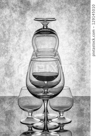 Still life with glass objects on a gray background 129145010