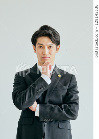 一位二十多歲的年輕律師，手托著下巴思考 129145536