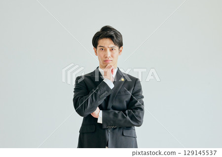 一位二十多歲的年輕律師，手托著下巴思考 129145537