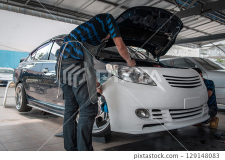 Checking car body work fiber bumper at car garage 129148083