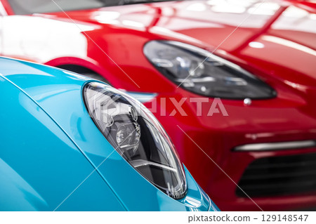 Car headlight of blue and red automobile. Car headlight of blue and red automobile. 129148547