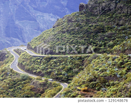 An asphalt road among beautiful mountains covered with tropical forest and cacti, view from above. 129148676
