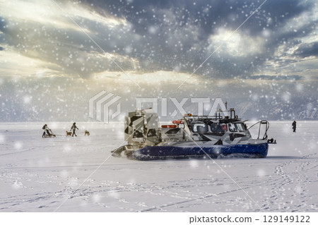 People travel, dogsledding on the ice of frozen Baikal Lake in a safe and comfortable Hivus hovercraft. People travel, dogsledding on the ice of frozen Baikal Lake in a safe and comfortable Hivus hovercraft. 129149122