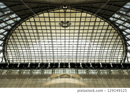Clean airport waiting area interior with seats and windows. Clean airport waiting area interior with seats and windows. 129149125