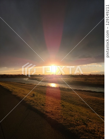 A beautiful sunset seen from the riverbank A beautiful sunset seen from the riverbank 129149211