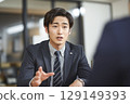 一位穿著西裝微笑的年輕商人 129149393