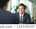 一位穿著西裝微笑的年輕商人 129149397