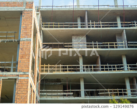 House made of red blocks and reinforced concrete. Wooden sides for safety at construction sites 129149876