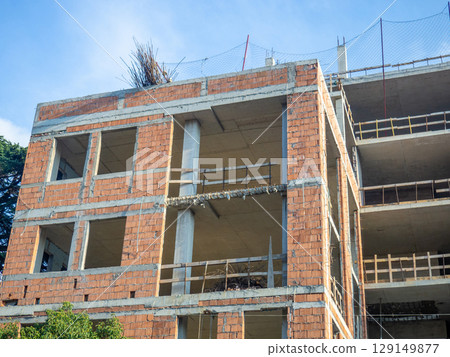 House made of red blocks and reinforced concrete. Wooden sides for safety at construction sites House made of red blocks and reinforced concrete. Wooden sides for safety at construction sites 129149877