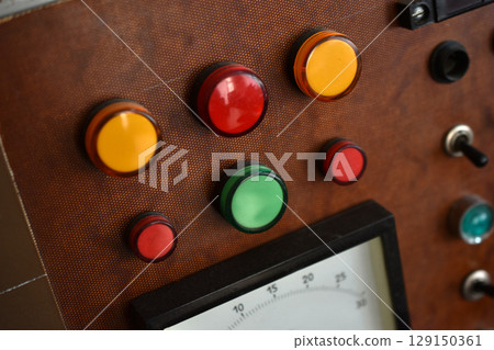 An old control board with a voltmeter, switches and lamps. Electronic control panel with buttons and toggle switches. The old management system. 129150361