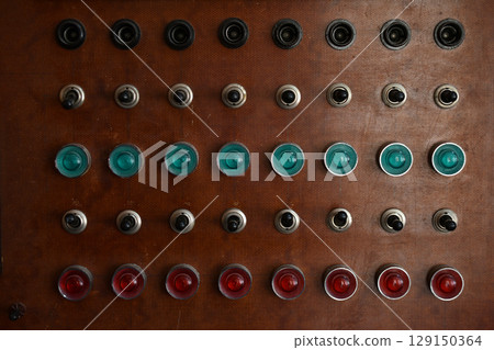 An old control board with a voltmeter, switches and lamps. Electronic control panel with buttons and toggle switches. The old management system. An old control board with a voltmeter, switches and lamps. Electronic control panel with buttons and toggle switches. The old management system. 129150364
