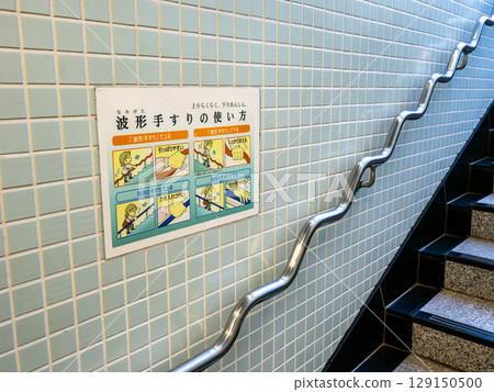 Wave-shaped handrails and instructions installed on stairs in a public facility 129150500