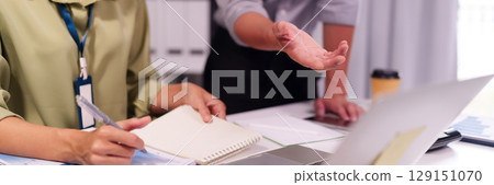 Business professionals collaborating analyzing financial data discussing project strategy in modern office environment meeting room setting 129151070
