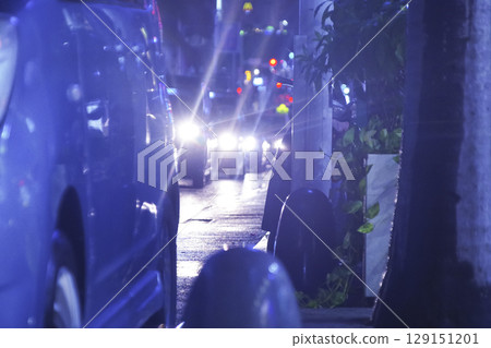 Neon lights and cars reflected on a wet road 129151201