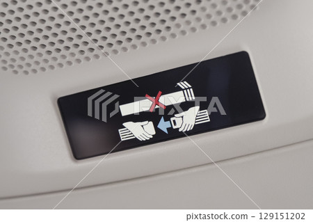 Seat belt sign inside an airplane 129151202