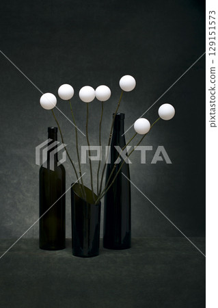 Still life with glassware and a bouquet of white balls 129151573