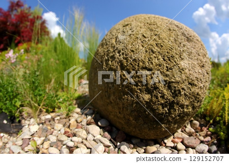 A Ground Stone Sphere positioned elegantly within a serene and natural landscape setting 129152707