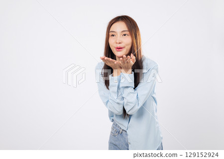 Air filled with love as woman blowing a kiss from her mouth, second woman uses hands and palms to send sweet emotion, isolated on white background. Air filled with love as woman blowing a kiss from her mouth, second woman uses hands and palms to send sweet emotion, isolated on white background. 129152924