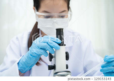 Scientist medical professional use microscope for research in science laboratory. 129153143
