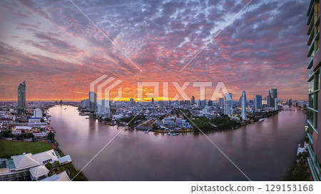Panorama view of modern buildings in the city with water reflection, firework, light show at twilight time. 129153168