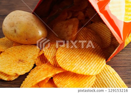 Potato chips in open bag, delicious BBQ seasoning spicy for crips, thin slice deep fried snack fast food. 129153216
